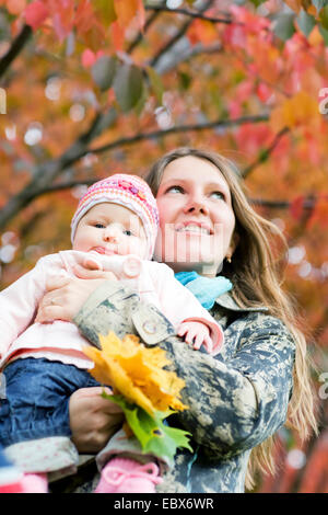 Junge Mutter mit Tochter genießen schöne Herbsttag Stockfoto
