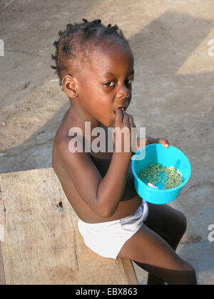 dunkelhäutige Junge isst Reis mit seinen Händen, Nigeria Stockfoto