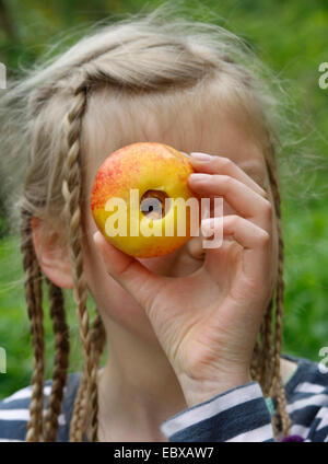 Mädchen sucht durch einen Apfel aus dem Kern ausgelagert wurde, Deutschland Stockfoto