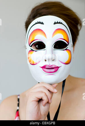 junge Frau hinter der Maske Stockfoto