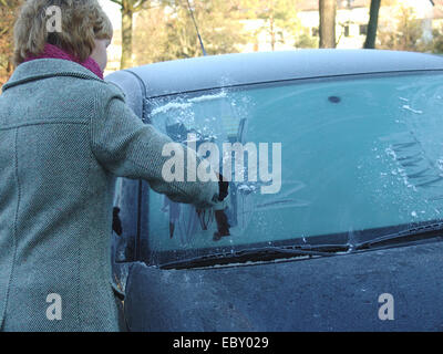 Frau kratzt Eis von der Frontscheibe ihres Autos Im Winter Stockfotografie  - Alamy