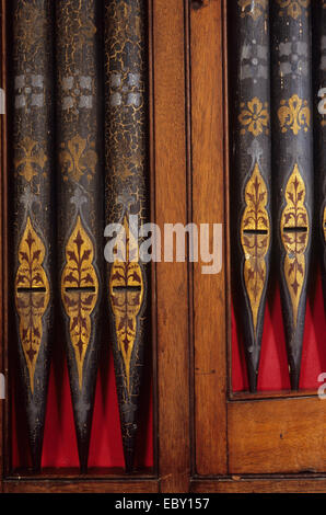 Detail der Kirche Orgelpfeifen in Holz mit rotem Tuch hinter gerahmt und in gold rot und Silber mit reich verzierten Blattentwurf gemalt Stockfoto