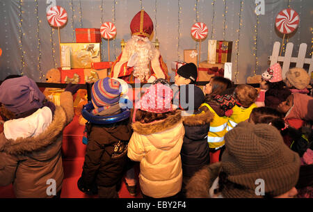 (141205)--Brüssel, Dec.5, 2014 (Xinhua)--Kinder warten, mit "Saint Nicolas" während der Saint Nicolas-Festival in Brüssel, Belgien, 5. Dezember 2014 zu sprechen. Saint Nicolas Festival kommt traditionell in den Niederlanden und Belgien jedes Jahr Mitte November oder Dezember. Parade durch die Straßen auf seinem Pferd mit seinem hilfreicher Assistent Black Pete, ist er traditionell die Kinder jubeln und singen traditionelle Nikolaus begrüßt. (Xinhua / Ye Pingfan) Stockfoto