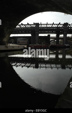 Sonne Porträt dunklen Bogen Salford Kreuzung Viadukt zu großen nördlichen Viadukt reflektierenden Wasser, Castlefield Canal Basin, Manchester Stockfoto