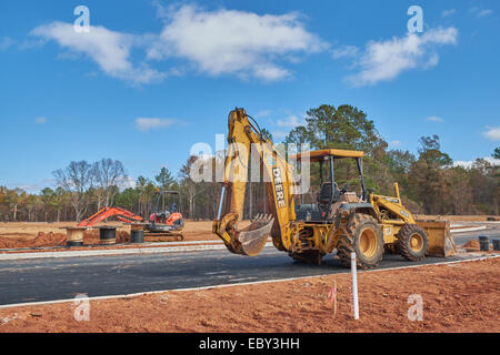 Ein John Deere-Tieflöffel/Frontlader im Vordergrund mit einem kleineren Kubota-Tieflöffel im Hintergrund auf einer Baustelle, Pike Road, Alabama, USA. Stockfoto