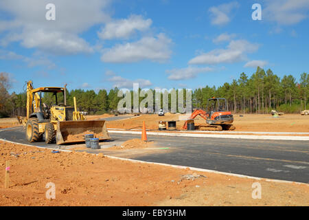 Ein John Deere-Tieflöffel/Frontlader im Vordergrund mit einem kleineren Kubota-Tieflöffel im Hintergrund auf einer Baustelle, Pike Road, Alabama, USA. Stockfoto