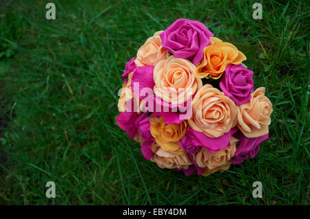 Rosa, Pfirsich und orange Braut Blumen vor dem Hintergrund der grünen Rasen. Stockfoto