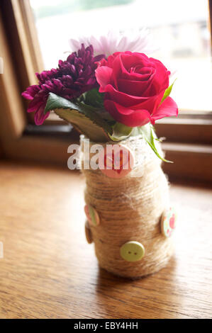Rosa, roten und weißen Blüten in einer schmalen vase Stockfoto