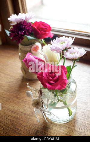 Rosa, roten und weißen Blüten in einer schmalen vase Stockfoto