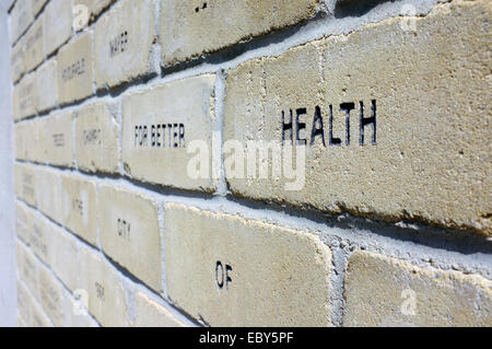 Eine Mauer aus Ziegeln mit dem Wort "Gesundheit" sichtbar. Stockfoto