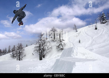 Snowboarder bei extremen Sprung im Hochgebirge am sonnigen Tag Stockfoto