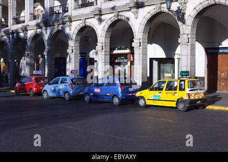 Taxis stehen in Linie entlang der Torbogen des Portal de San Agustin an der Plaza de Armas (Hauptplatz) in Arequipa, Peru Stockfoto