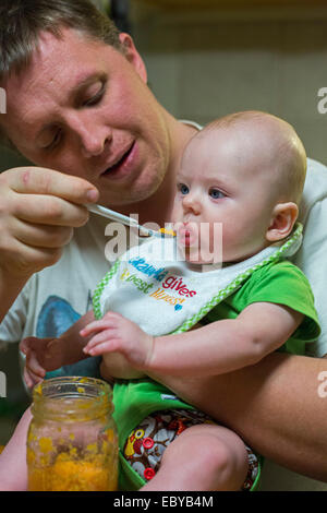 Denver, Colorado - Adam Hjermstad Sr. füttert seinen vier Monate alten Sohn, Adam Jr. Stockfoto