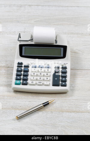 Vertikales Bild von einem alten Finanz-Taschenrechner mit Papier und Stift auf hölzernen desktop Stockfoto