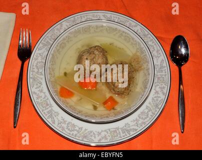 Matzo Ball Suppe auf einer Orangen Tischdecke. Stockfoto