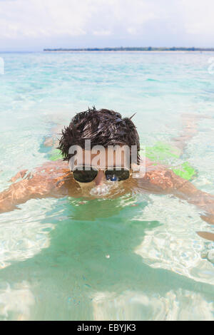 Junger Mann mit Sonnenbrille, Gili-Inseln, Indonesien zu schwimmen Stockfoto