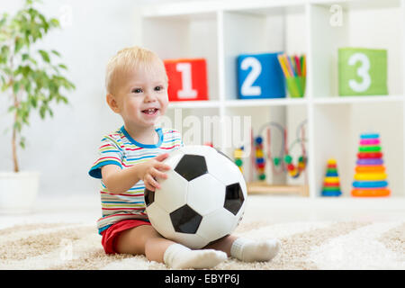 Kid Boy mit Fußball indoor Stockfoto