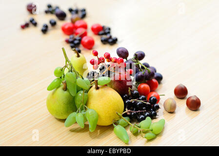 Beeren, Obst, Gemüse und Nüssen zufällig verstreut auf einem Tisch Stockfoto