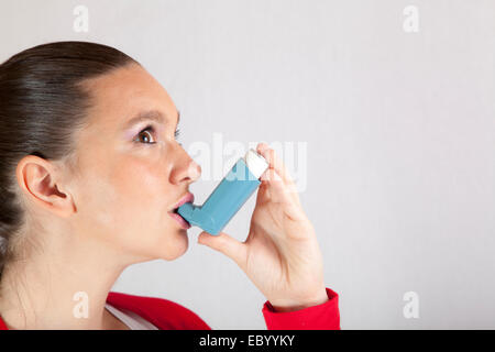 Ziemlich lächelndes Mädchen mit Asthma-Inhalator Stockfoto