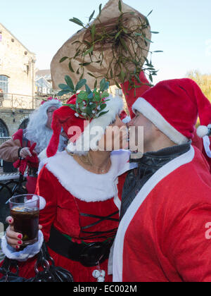 London, UK. 6. Dezember 2014. Zwei Weihnachtsmänner Kuss unter einem Mistelzweig. Hunderte von Weihnachtsmänner versammelten sich in Camden Market, auf den jährlichen Santacon Flashmob führt sie rund um London. Drei verschiedene Ansatzpunkte wurden für das diesjährige Treffen ausgewählt. Bildnachweis: Nick Savage/Alamy Live-Nachrichten Stockfoto