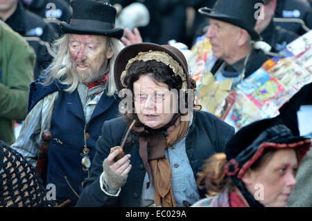 Rochester, Kent, UK. 6. Dezember 2014. Dickens Christmas Festival - Parade durch die Hauptstraße der Stadt. Frau in Tracht mit einem Rohr Stockfoto