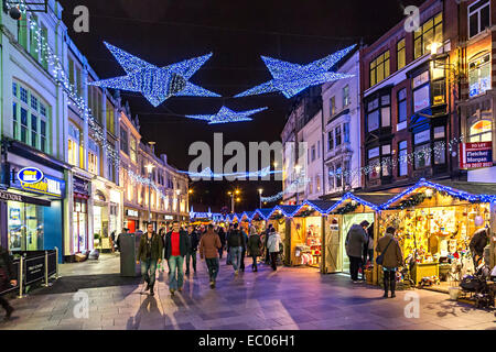 Weihnachtsschmuck und Shopper in Straße mit Weihnachten Markt, Cardiff, Wales, UK Stockfoto