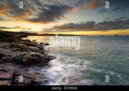 Wellen an den Felsen bei Sonnenuntergang in North Berwick, East Lothian, Schottland. Stockfoto