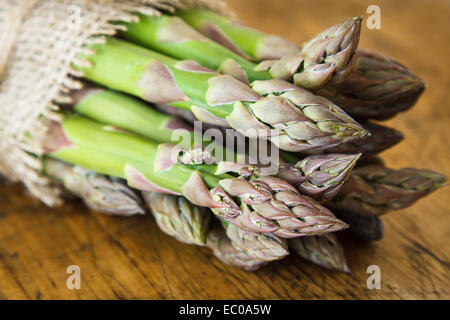 Grüner Spargel auf hölzernen Hintergrund Stockfoto