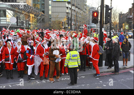 London, UK. 6. Dezember 2014. Menschen als Weihnachtsmann verkleidet bei den alljährlich stattfindenden "SantaCon" in Camden, North London.  Santacon Veranstaltungen statt finden in verschiedenen Städten auf der ganzen Welt in den Wochen vor Weihnachten. Die Parade, die Teil-Flash-Mob, Kneipentour Teil, hat einen Schwerpunkt auf Spaß und saisonale guten Mutes auf Passanten zu verbreiten. Bildnachweis: Michael Preston/Alamy Live-Nachrichten Stockfoto