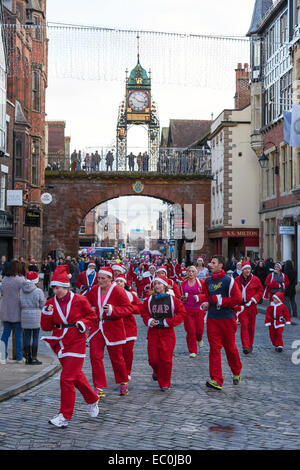 Chester, UK. 7. Dezember 2014. Wettbewerber unterqueren die Eastgate Clock in der 2014 Nächstenliebe Santa Dash durch die Straßen von Chester City Centre UK. Bildnachweis: Andrew Paterson/Alamy Live-Nachrichten Stockfoto