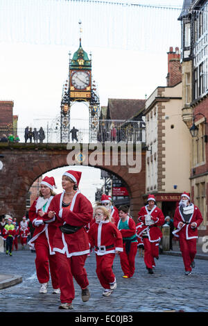 Chester, UK. 7. Dezember 2014. Wettbewerber unterqueren die Eastgate Clock in der 2014 Nächstenliebe Santa Dash durch die Straßen von Chester City Centre UK. Bildnachweis: Andrew Paterson/Alamy Live-Nachrichten Stockfoto