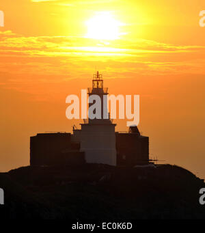 Mumbles Leuchtturm bei Sonnenaufgang mit goldenen Sonne über dem Light Tower. Mumbles war der beste Ort in Wales 2018 zu Leben gestimmt. Stockfoto