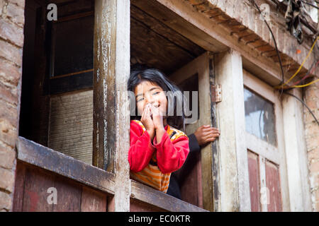 Namaste, Napali-Mädchen in einem Fenster in Bhaktapur, Nepal Stockfoto