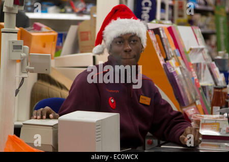 Wimbledon London, UK. 7. Dezember 2014. Mitarbeiter bei einer Sainsburys Supermarkt Filiale bekommen in Weihnachtsstimmung durch das Tragen von Father Christmas Santa Hüte Credit: Amer Ghazzal/Alamy Live-Nachrichten Stockfoto