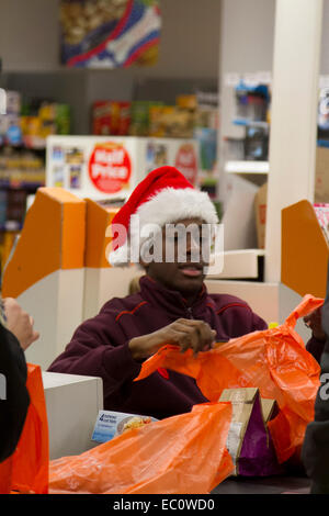 Wimbledon London, UK. 7. Dezember 2014. Mitarbeiter bei einer Sainsburys Supermarkt Filiale bekommen in Weihnachtsstimmung durch das Tragen von Father Christmas Santa Hüte Credit: Amer Ghazzal/Alamy Live-Nachrichten Stockfoto