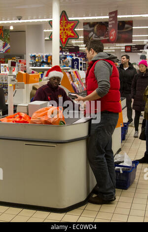 Wimbledon London, UK. 7. Dezember 2014. Mitarbeiter bei einer Sainsburys Supermarkt Filiale bekommen in Weihnachtsstimmung durch das Tragen von Father Christmas Santa Hüte Credit: Amer Ghazzal/Alamy Live-Nachrichten Stockfoto