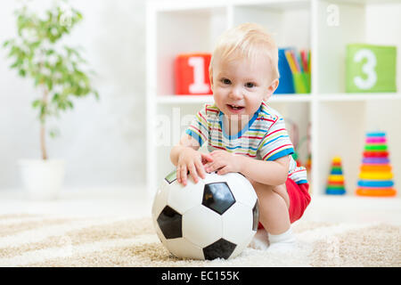 Kid Boy mit Fußball indoor Stockfoto