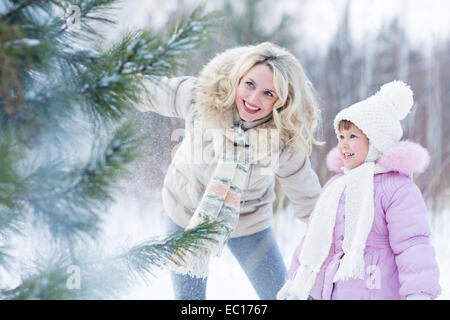 Glückliche Eltern und Kind spielt mit Schnee im Winter im freien Stockfoto