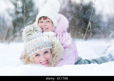 Glückliche Eltern und Kind spielt mit Schnee im Winter im freien Stockfoto