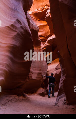 junger Mann erkunden Slot Canyons in Page Arizona mit schönen Schattierungen von rot und orange Stockfoto