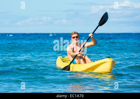 Mann Kajak im tropischen Ozean in gelben Kajak an sonnigen Morgen in Hawaii Stockfoto