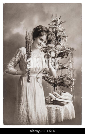 junge Frau mit Weihnachtsbaum und Geschenke. antikes Bild mit original Kratzer und Film-Korn Stockfoto