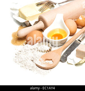 Backen, Zutaten und Werkzeuge für die Teigbereitung. Mehl, Eiern, Zucker, Butter, Nudelholz und Ausstechformen auf weißen staatlich Stockfoto