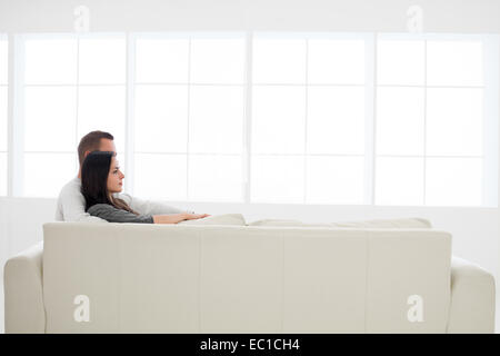 Seitenansicht des kaukasischen Pärchen gemeinsam entspannen auf der Couch Suche vor Stockfoto