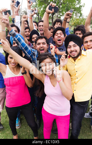 indische Gruppe Massen Parken sprechendes Telefon Stockfoto