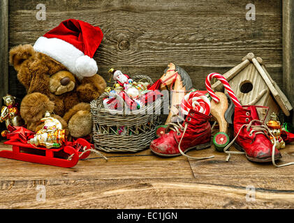 nostalgischer Weihnachtsschmuck mit antiken Spielsachen über hölzerne Hintergrund. Retro-Stil getönten Bild Stockfoto