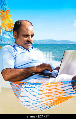 indischer Mann Strand funktionierende laptop Stockfoto
