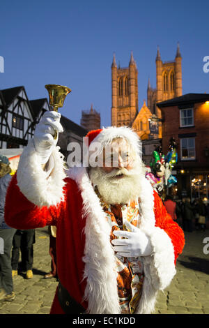 Weihnachtsmann auf dem Marktplatz während des Weihnachtsmarktes mit der beleuchteten Kathedrale im Hintergrund Stockfoto