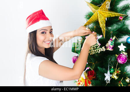 ein indisches Mädchen Weihnachtsbaum binden Geschenk Stockfoto