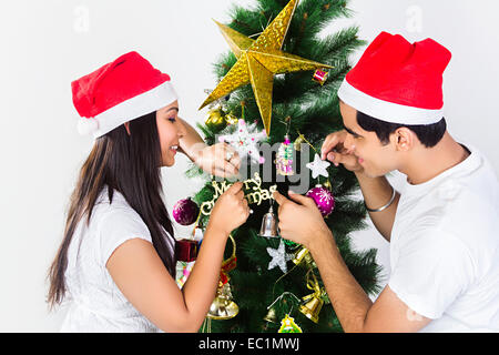 indischer Freund Weihnachtsbaum binden Geschenk Stockfoto